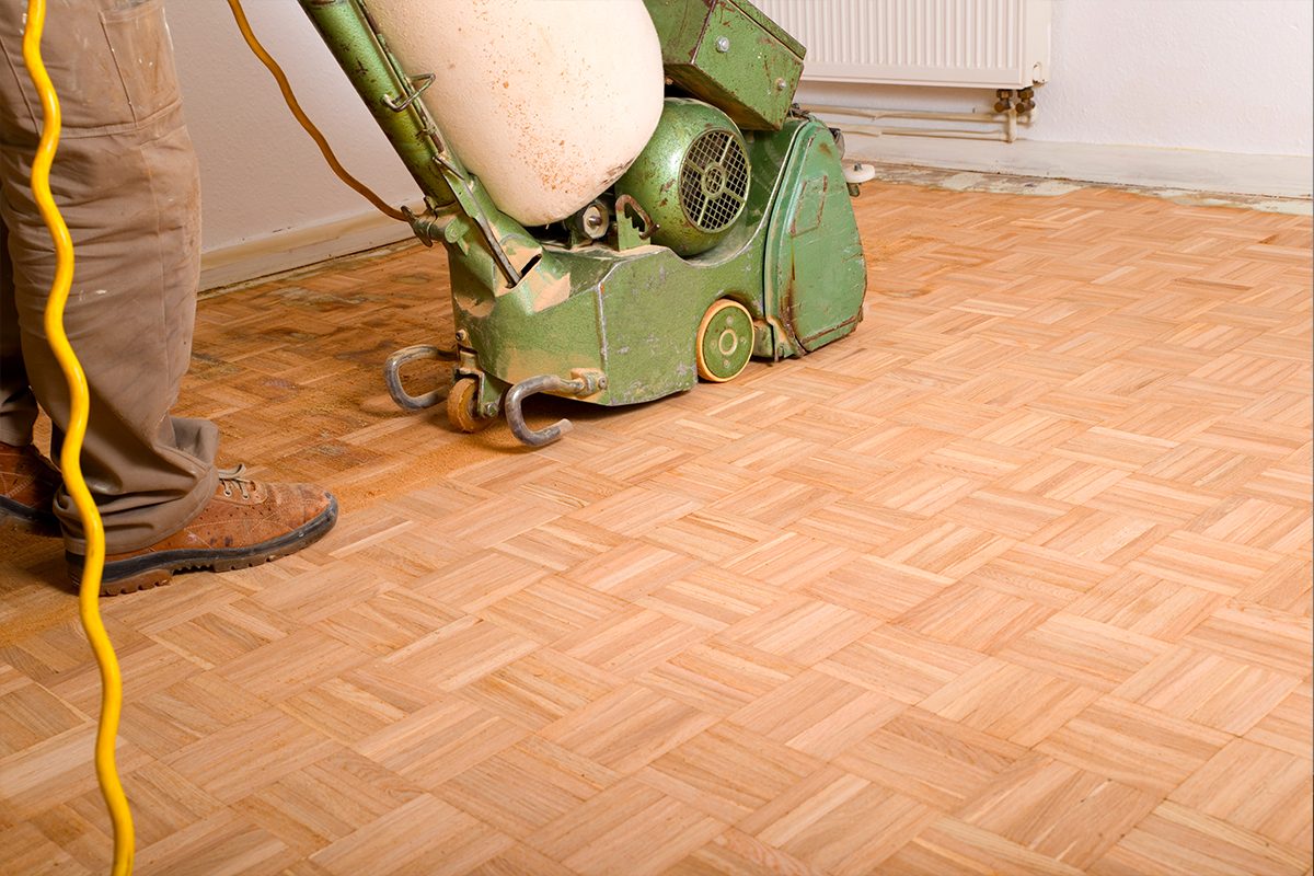 Afagar parquet em mosaico tradicional num prédio antigo de Lisboa